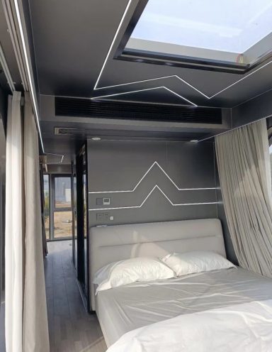 Schlafzimmer mit grauen Wänden, einem großen Fenster und einem modernen Bett.